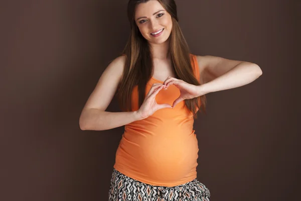 Těhotná žena s tvaru srdce — Stock fotografie