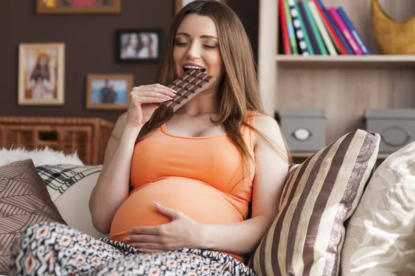 Mujer embarazada comiendo chocolate — Foto de Stock