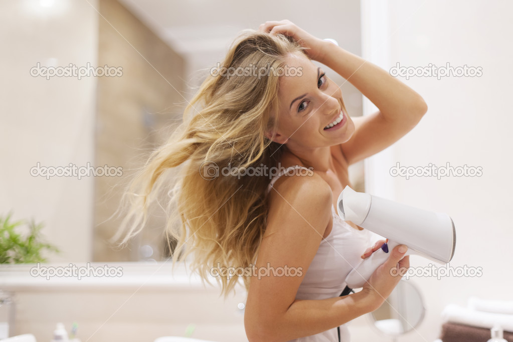 Blonde woman drying hair