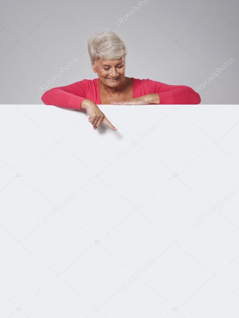 Senior woman peeking on whiteboard
