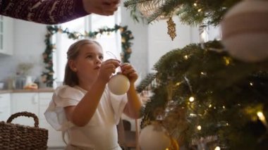 Baba ve kızı Noel ağacını süslüyorlar. 8K 'da kırmızı helyum kamerayla çekildi.