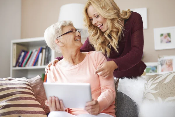 Mädchen zeigt etwas Lustiges auf digitalem Tablet — Stockfoto