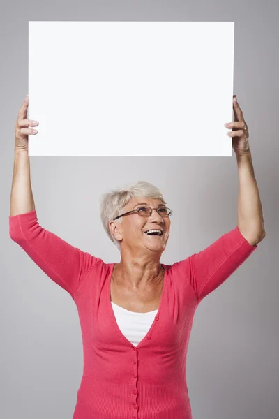 Äldre kvinna anläggning whiteboard — Stockfoto