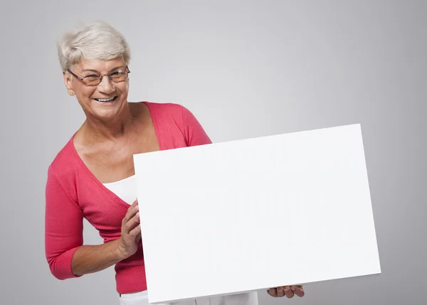 Senior mulher segurando quadro branco — Fotografia de Stock