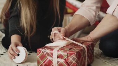 Noel hediyelerini paketleyen mutlu büyükanne ve torunun videosu. 8K 'da kırmızı helyum kamerayla çekildi..