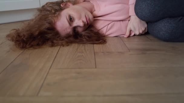 床に横たわっ落ち込んでいる若い白人女性のビデオでズーム 8Kでレッドヘリウムカメラで撮影 — ストック動画