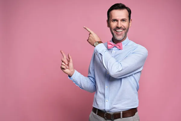 Sonriente Hombre Mostrando Pared Rosa —  Fotos de Stock