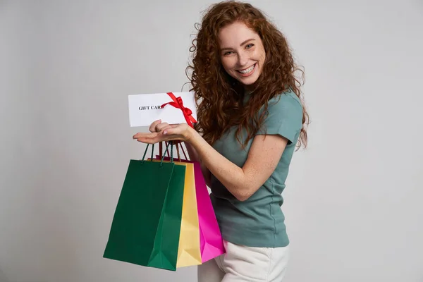 ショッピングバッグやギフトカードを持つ幸せな女性 — ストック写真