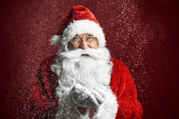 在红色背景下吹雪的高加索圣诞老人的近照 — 图库照片