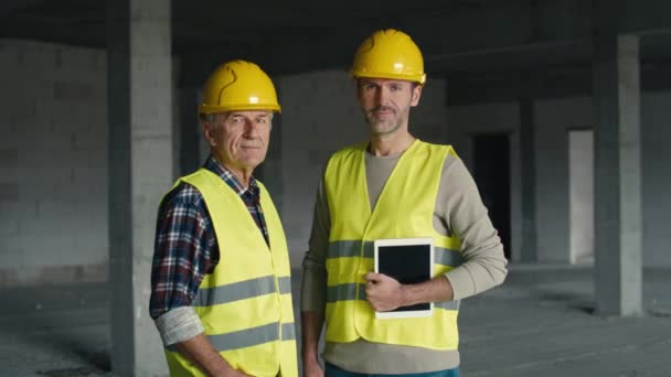 Portré Két Kaukázusi Mérnökről Akik Digitális Táblagépet Tartanak Miközben Építkezésen — Stock videók
