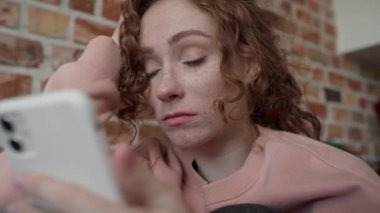 Genç beyaz kadının cep telefonu kullandığı düşük açılı videoyu kapat. 8K 'da kırmızı helyum kamerayla çekildi..