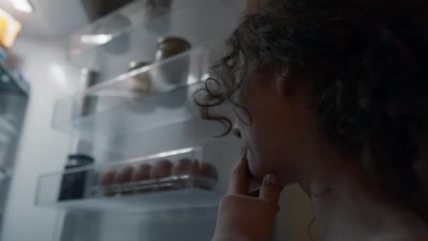 夜に冷蔵庫をチェックする未定の若い白人女性 8Kでレッドヘリウムカメラで撮影 — ストック動画