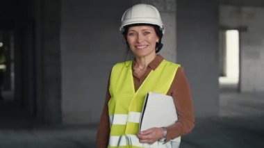 İnşaat alanında duran beyaz kadın mühendisin portresi. 8K 'da kırmızı helyum kamerayla çekildi.       