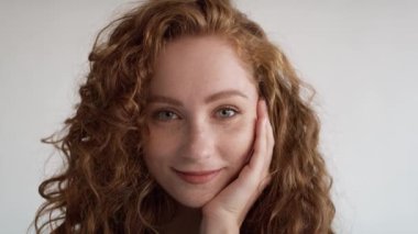 Beyaz arka planda gülen beyaz bir kadının yakın portresi. 8K 'da kırmızı helyum kamerayla çekildi..