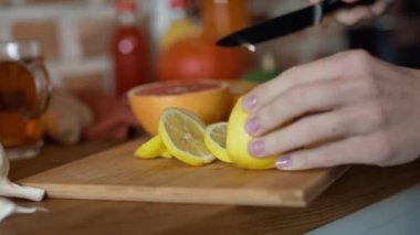 Kış çayı için limon kesen tanınmamış kadının elleri. 8K 'da kırmızı helyum kamerayla çekildi..