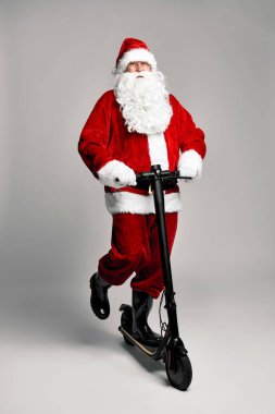 Beyaz Noel Baba elektrikli scooter kullanıyor.