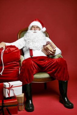 Kafkas Noel Baba 'sı Noel hediyeleriyle retro sandalyede oturuyor.