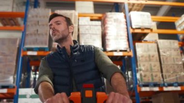 Depoda forklift iterek çalışan yetişkin beyaz bir adam. 8K 'da kırmızı helyum kamerayla çekildi.. 