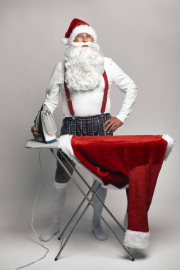 Beyaz Noel Baba Noel için pantolon ütülüyor. 