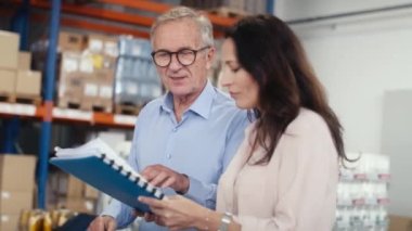 Depodaki belgeleri inceleyen olgun kadın ve adam. 8K 'da kırmızı helyum kamerayla çekildi..  