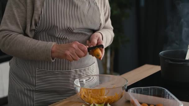 Dettaglio Donna Anziana Caucasica Che Sbuccia Una Carota Mentre Cucina — Video Stock