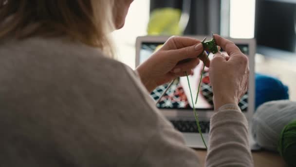 ビデオチュートリアルから編む方法を学ぶ自宅で白人のシニア女性の閉鎖 8Kでレッドヘリウムカメラで撮影 — ストック動画