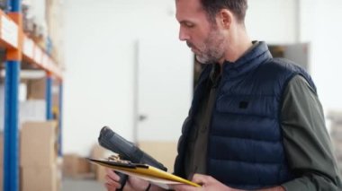 Depoda çalışan yetişkin beyaz bir adam. 8K 'da kırmızı helyum kamerayla çekildi..  