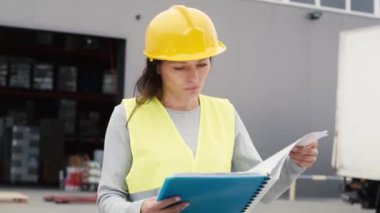 Deponun önünde cep telefonuyla konuşan beyaz bir kadın. 8K 'da kırmızı helyum kamerayla çekildi..