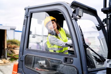 Yetişkin beyaz kadın forklift kullanıyor. 