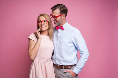 Caucasian couple at Valentine's Day posing on pink background