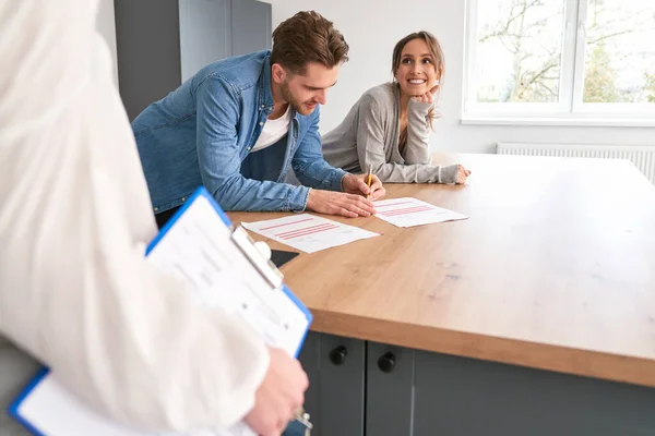Young Caucasian Couple Signing House Buying Agreement —  Fotos de Stock