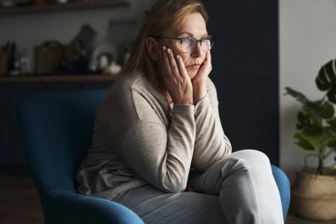 Caucasian senior woman with problems sitting on the chair 