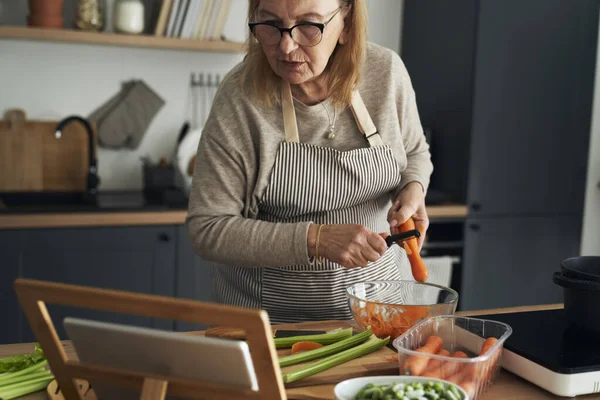 Kaukasiska Äldre Kvinna Skala Morot Medan Matlagning Köket — Stockfoto