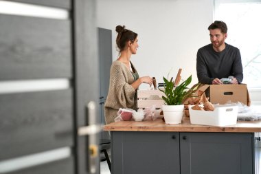 Kafkasyalı çift sohbet ediyor ve mutfak eşyaları paketliyor.