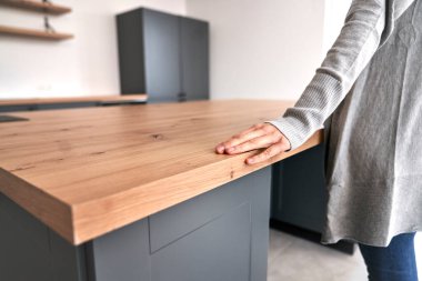 Unrecognizable woman stroking kitchen isle in her new house