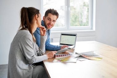Caucasian couple choosing project of new kitchen 