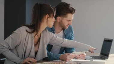 Beyaz çift mutfakta oturuyor ve yeni daire için renk seçiyorlar. 8K 'da kırmızı helyum kamerayla çekildi. 