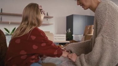 Beyaz anne ve kızı mutfak eşyaları paketliyor. 8K 'da kırmızı helyum kamerayla çekildi. 