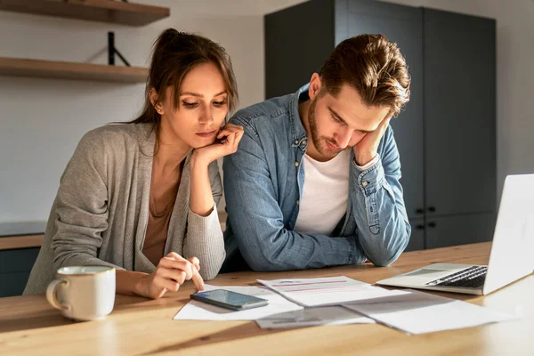 Miserable young caucasian couple having financial problems due to new house