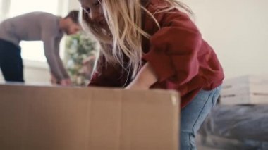 Beyaz bir aile yeni evde mutfak eşyaları paketliyor. 8K 'da kırmızı helyum kamerayla çekildi..