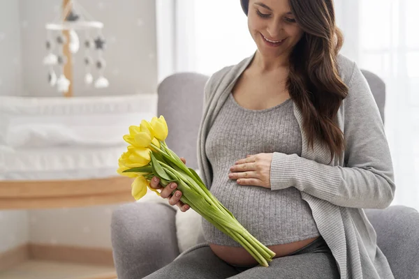 Biała Kobieta Zaawansowanej Ciąży Trzymająca Żółte Tulipany Dotykająca Brzucha — Zdjęcie stockowe