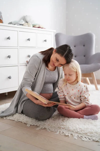 Blanke Vrouw Geavanceerde Zwangerschap Lezen Boek Met Haar Elementaire Dochter — Stockfoto
