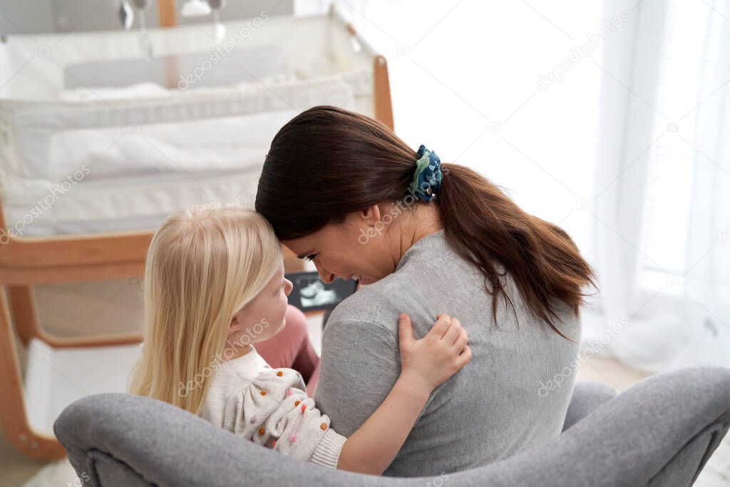 Rear view of caucasian woman in advanced pregnancy  playing with her elementary daughter