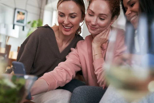Trzech Białych Przyjaciół Uśmiechających Się Podczas Przeglądania Smartfona — Zdjęcie stockowe