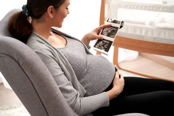 怀孕晚期的白人妇女在婴儿房间里浏览超声波扫描 — 图库照片