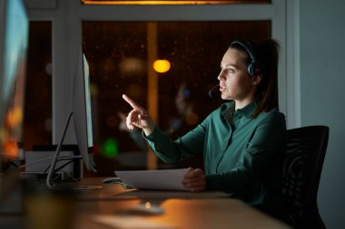 Yetişkin beyaz kadın geç saatlere kadar ofiste çalışıyor. 