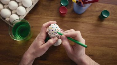 Paskalya yumurtalarını keçeli kalemle süsleyen insan eli ayrıntıları. 8K 'da kırmızı helyum kamerayla çekildi.   