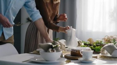 Beyaz aile Paskalya yemeği için masa hazırlıyor. 8K 'da kırmızı helyum kamerayla çekildi..
