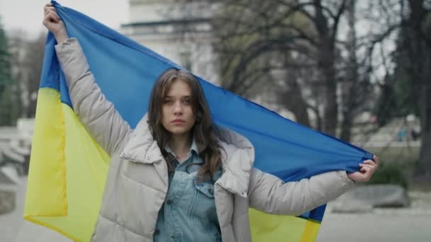 ウクライナ国旗を掲げた白人女性がカメラを見ていた 8Kでレッドヘリウムカメラで撮影 — ストック動画