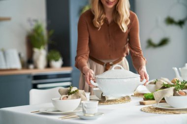 Elinde çorba vazosu olan tanınmayan bir kadın.